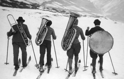 Athletes and the Arts - What we do - Traveling musicians - 4 musicians on skis in the mountains carrying trombone, euphonium, tuba, and bass drum